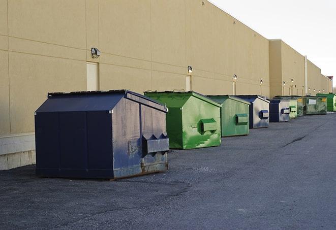 a series of colorful, utilitarian dumpsters deployed in a construction site in Indianola